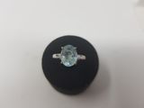 an oval aquamarinee gemstone ring on a black ring stand