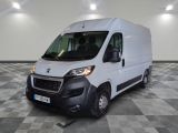 la camionnette blanche est garée sur un sol en damier dans le garage