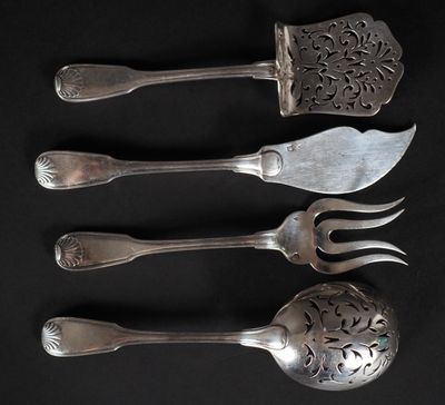 quatre fourchettes et cuillères sont alignées sur une surface noire