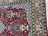an image of a red and blue rug on a gray floor