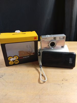 a small camera sitting next to a box on a table