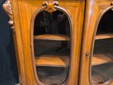 a wooden cabinet with a glass door and shelves