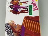 La poupée Barbie se trouve dans la boîte posée sur la table.