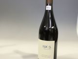 a bottle of wine sitting next to a glass of wine