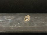 un diamant jaune posé sur une table en métal
