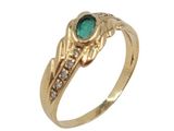gros plan d'une bague en or avec une pierre verte