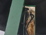 a black bag with a green handle and a bottle of wine in it