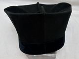 un chapeau noir posé sur un support métallique