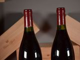two bottles of wine sitting on a table next to each other