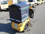 a small yellow motorcycle with a box on the back of it
