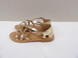 the gold sandals are on a white surface