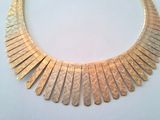 gold plated necklace on white surface with a white background