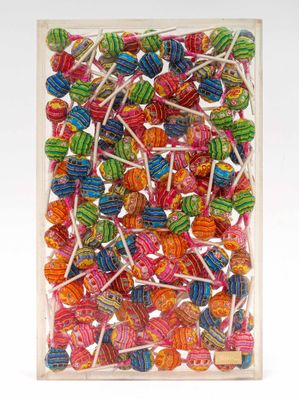 colorful lollipops in a clear box on a white background