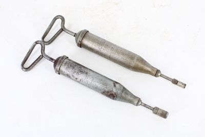 deux outils métalliques posés sur une surface blanche