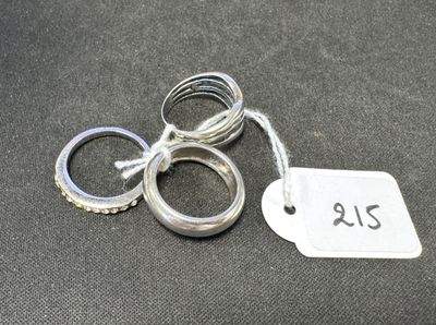 trois bagues et une étiquette de prix posées sur une table