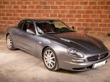 a silver sports car parked in front of a brick wall