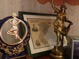 a table with a lamp, picture frame, and a statue on it