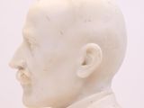 un gros plan sur une statue blanche représentant un homme chauve