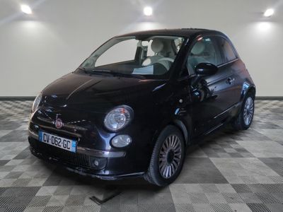 la photo d'une petite voiture noire sur un sol en damier