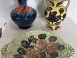 trois vases et une assiette posés sur une table