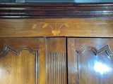 a close up of a wooden cabinet with a mirror above it
