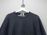 the back of a black sweater with a white bow on a hanger