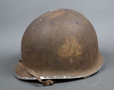 Un vieux casque est posé sur une table, avec une étiquette dessus.