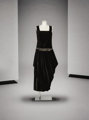 une robe noire posée sur un mannequin dans une pièce blanche