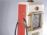 a red and white gas pump with a clock on top of it