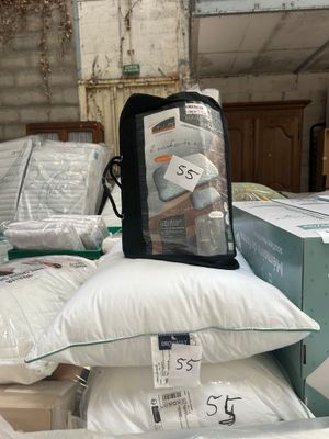 a pile of pillows and a bag on top of it