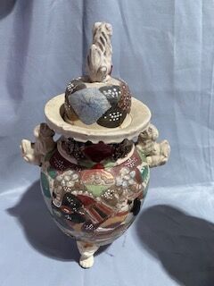 a small vase that has a bird on top of it
