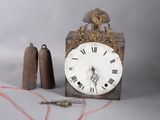 a clock that is sitting next to a pair of bells