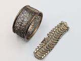 a close up of a bracelet and a ring on a white surface