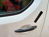 a close up of a car ' s door handle with a sticker on it