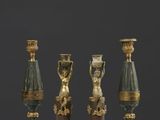quatre types de vases différents posés sur une table devant un fond noir