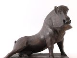 statue d'un sanglier posée sur un socle en bois, sur fond blanc