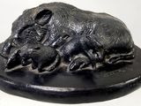 une statue représentant un éléphant et un éléphanteau, posée sur un socle noir