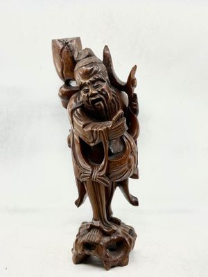 une statue en bois d'un homme avec un chapeau sur la tête