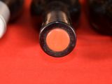several bottles of wine are lined up on a red surface