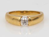 a close up of a diamond ring on a white surface