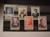 six different stamps on display in a glass case on a table
