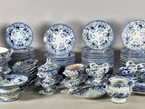 many blue and white dishes and cups on the table