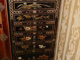 une commode noire et dorée dans un coin de la pièce