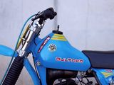 a blue dirt bike parked on the side of the road