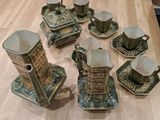 many cups and saucers sitting on a wooden table
