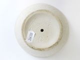a white vase with a tag on it on a white surface