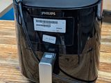 une friteuse à air chaud noire posée sur une table en bois