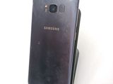 the back of a black samsung galaxy s7 phone sitting on top of a stand
