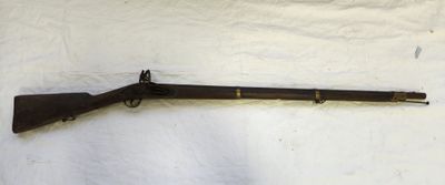 un fusil posé sur un drap blanc