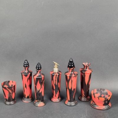 several red and black vases are lined up against a gray background